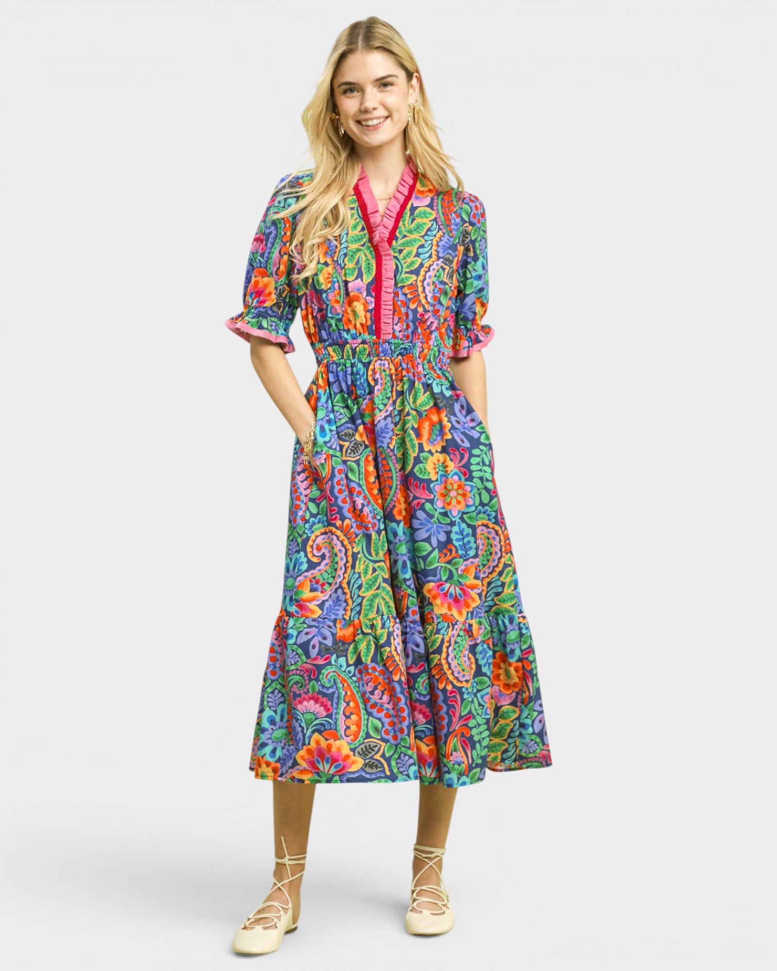 Woman wearing a colorful patterned dress on a white background