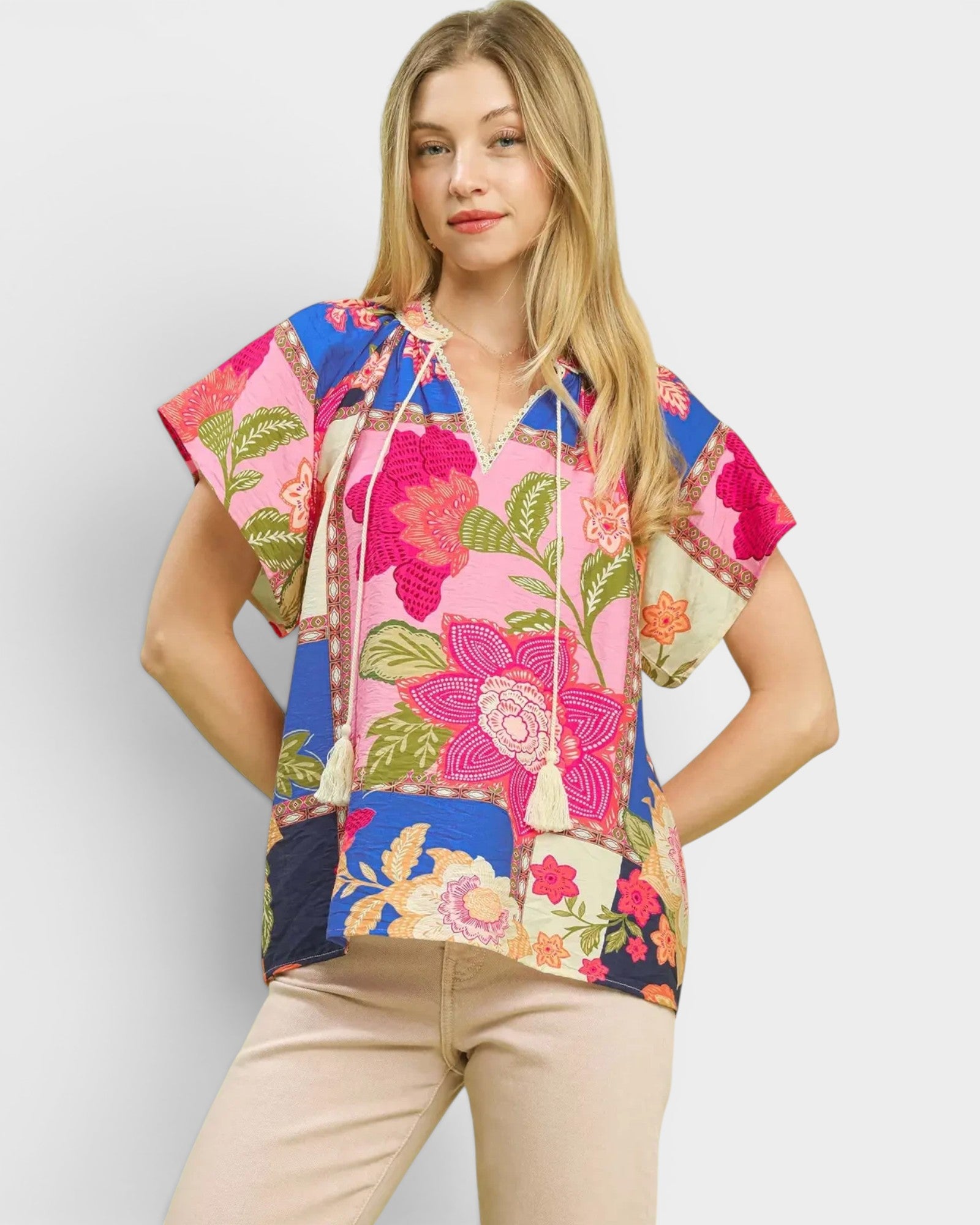Woman wearing a colorful floral hoodie against a plain background