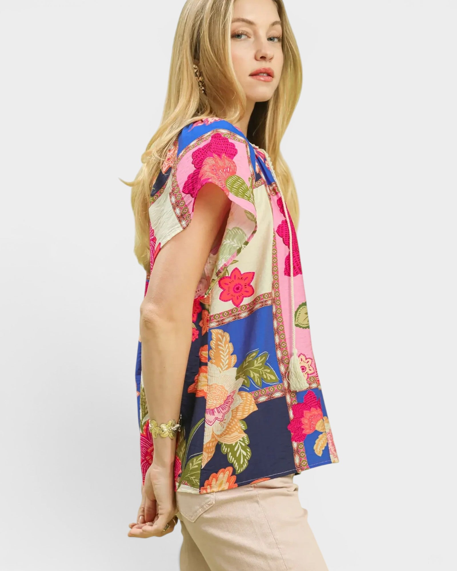 Woman wearing a colorful floral top on a white background