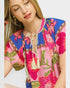 Woman wearing a colorful floral dress with a white background
