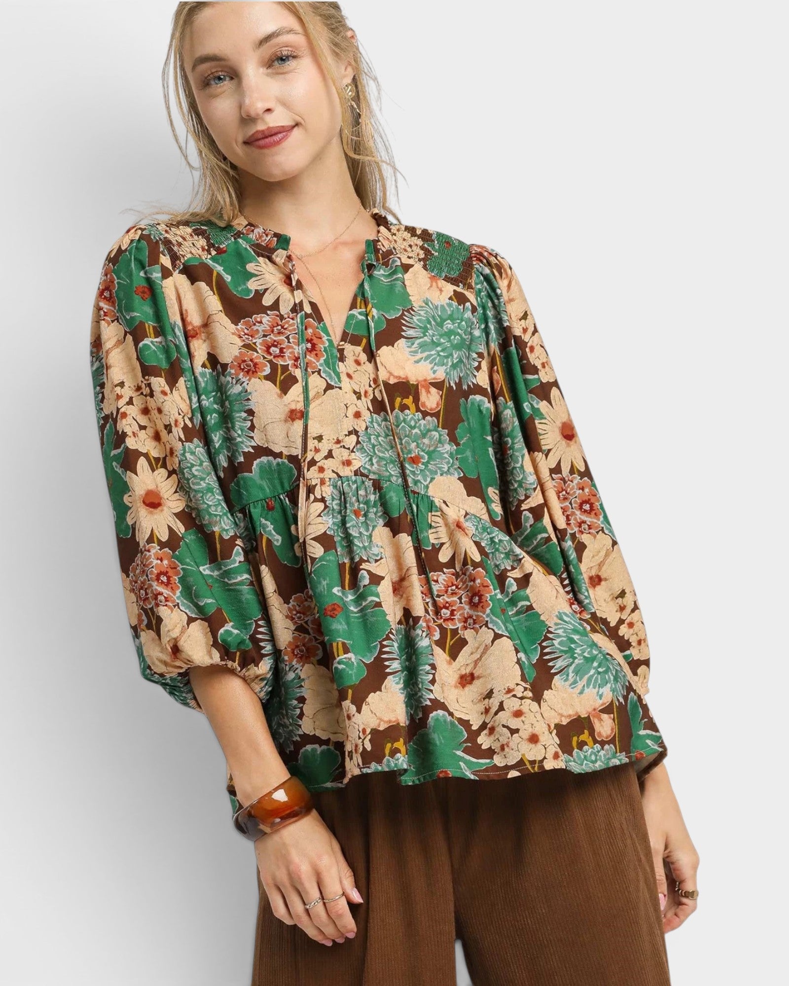 Woman wearing a floral blouse with a plain background