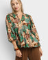 Woman wearing a floral blouse with a plain background