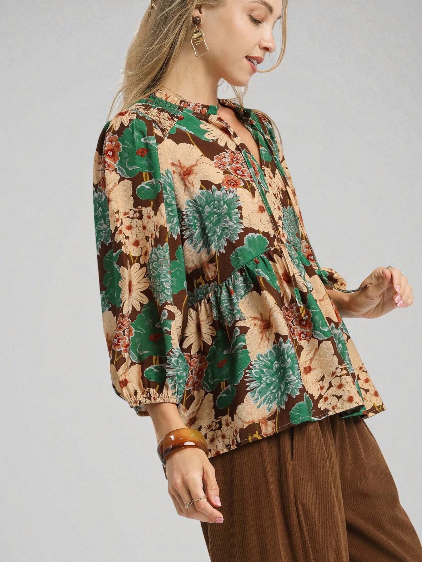 Woman wearing a floral blouse with a neutral background