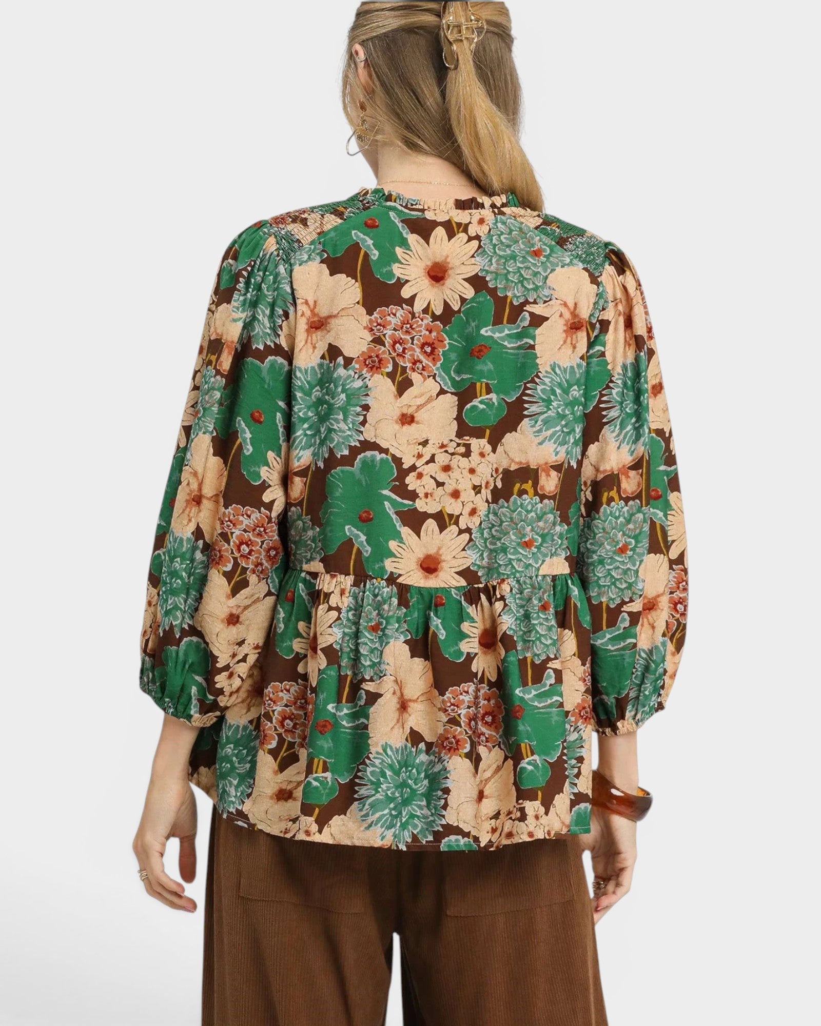 Person wearing a floral blouse with a white background