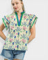 Woman wearing a colorful floral blouse with ruffled sleeves on a white background
