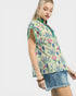 Woman wearing a floral blouse with a plain background
