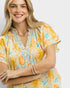 Woman wearing a colorful floral dress with embroidery on a white background