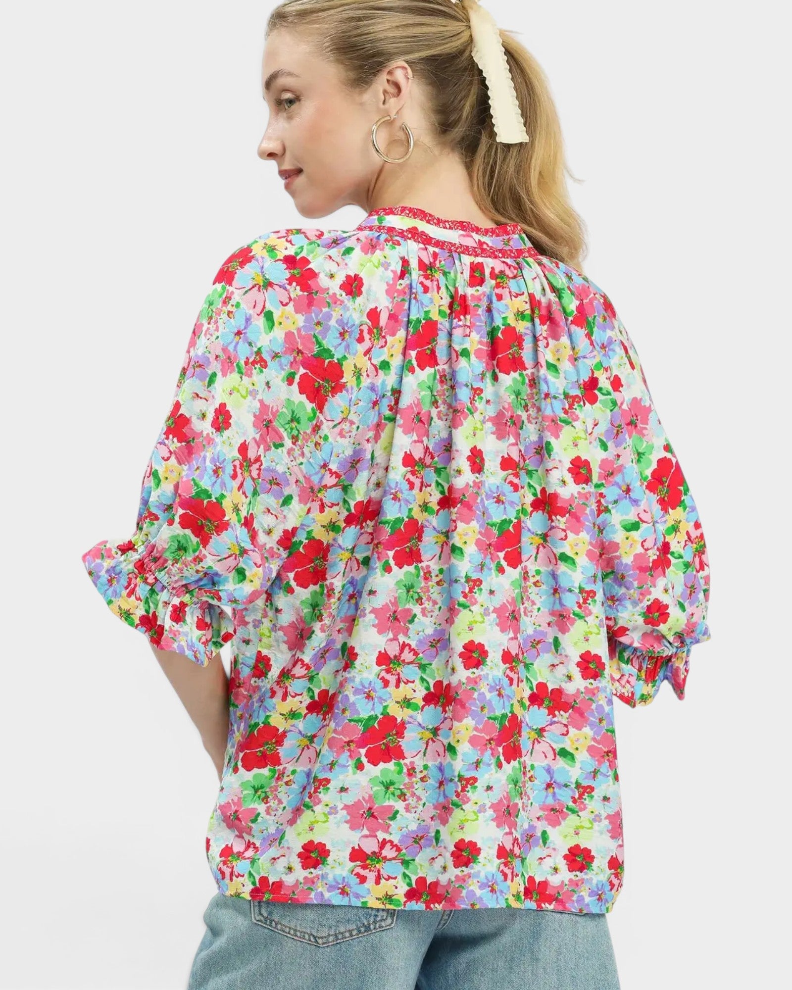 Woman wearing a colorful floral blouse on a white background