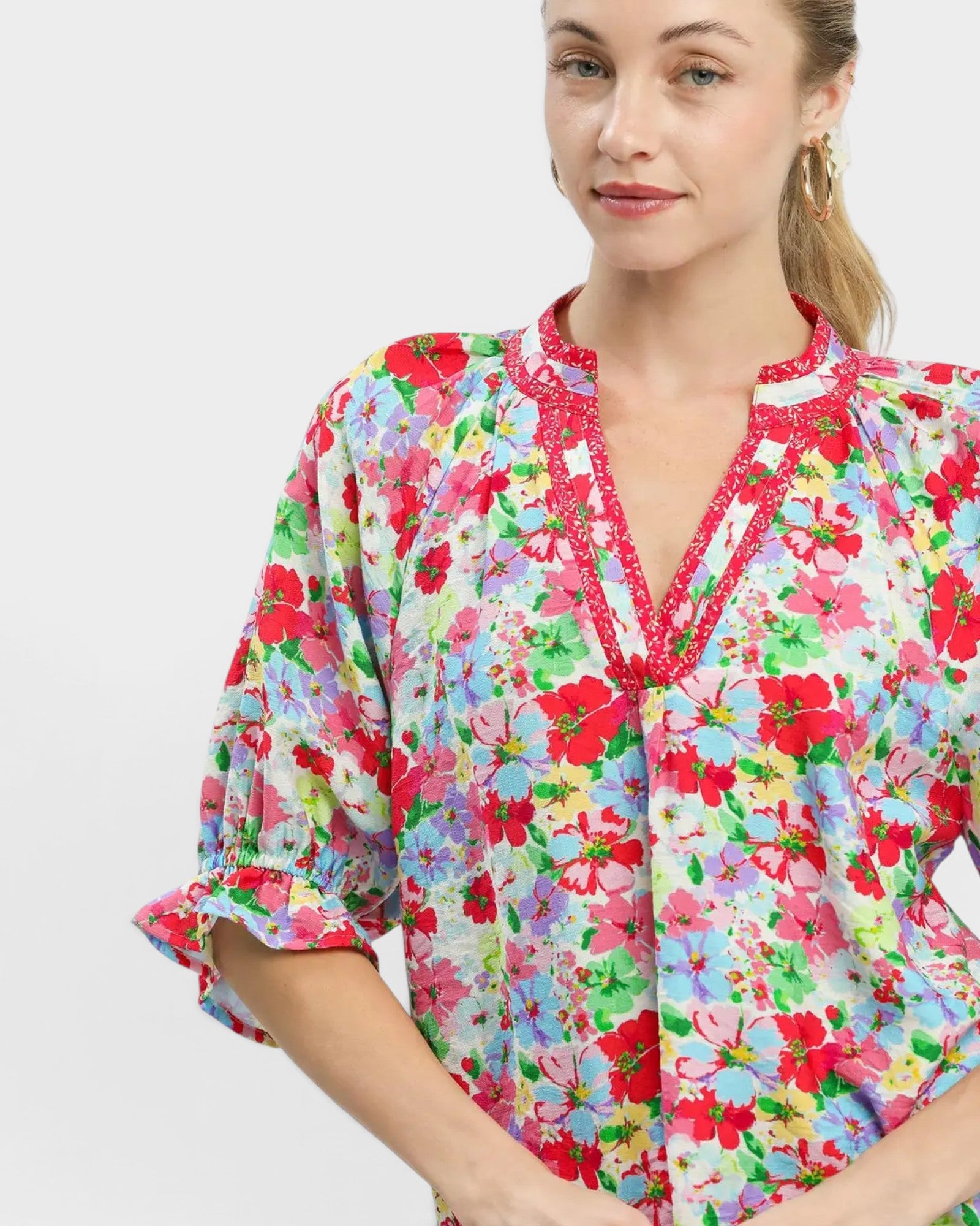 Woman wearing a colorful floral dress on a white background