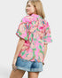 Woman wearing a pink floral kimono-style top on a plain background