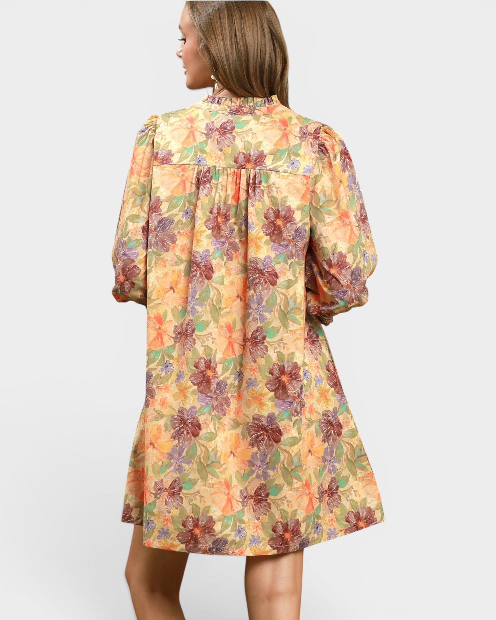 Woman wearing a floral dress with a plain background
