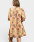 Woman wearing a floral dress with a plain background