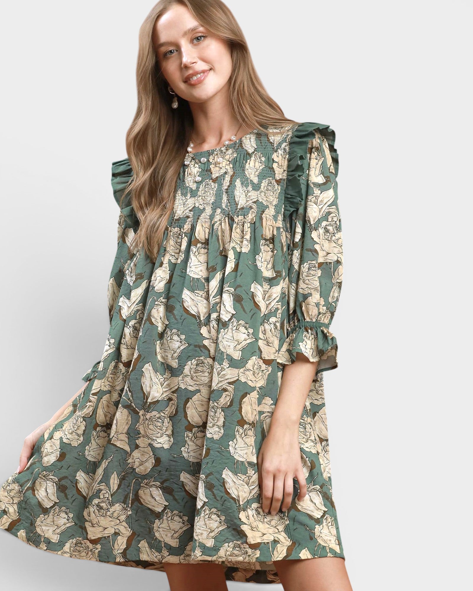 Woman wearing a green floral dress on a light gray background