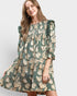 Woman wearing a green floral dress on a light gray background