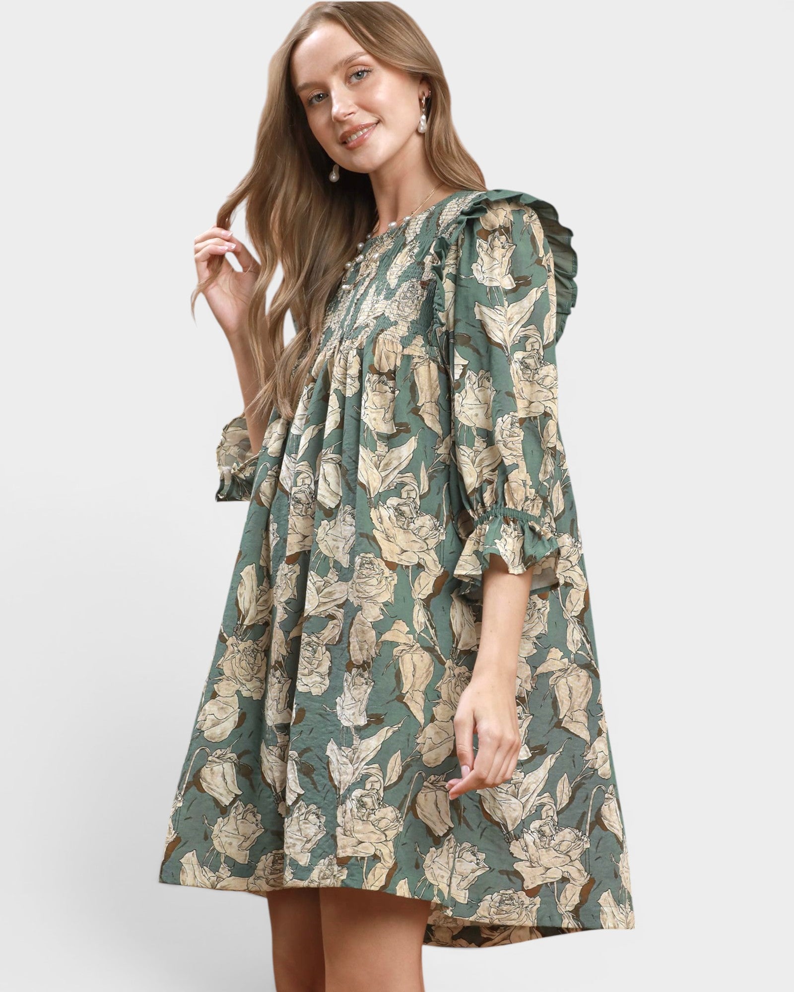 Woman wearing a green floral dress on a white background