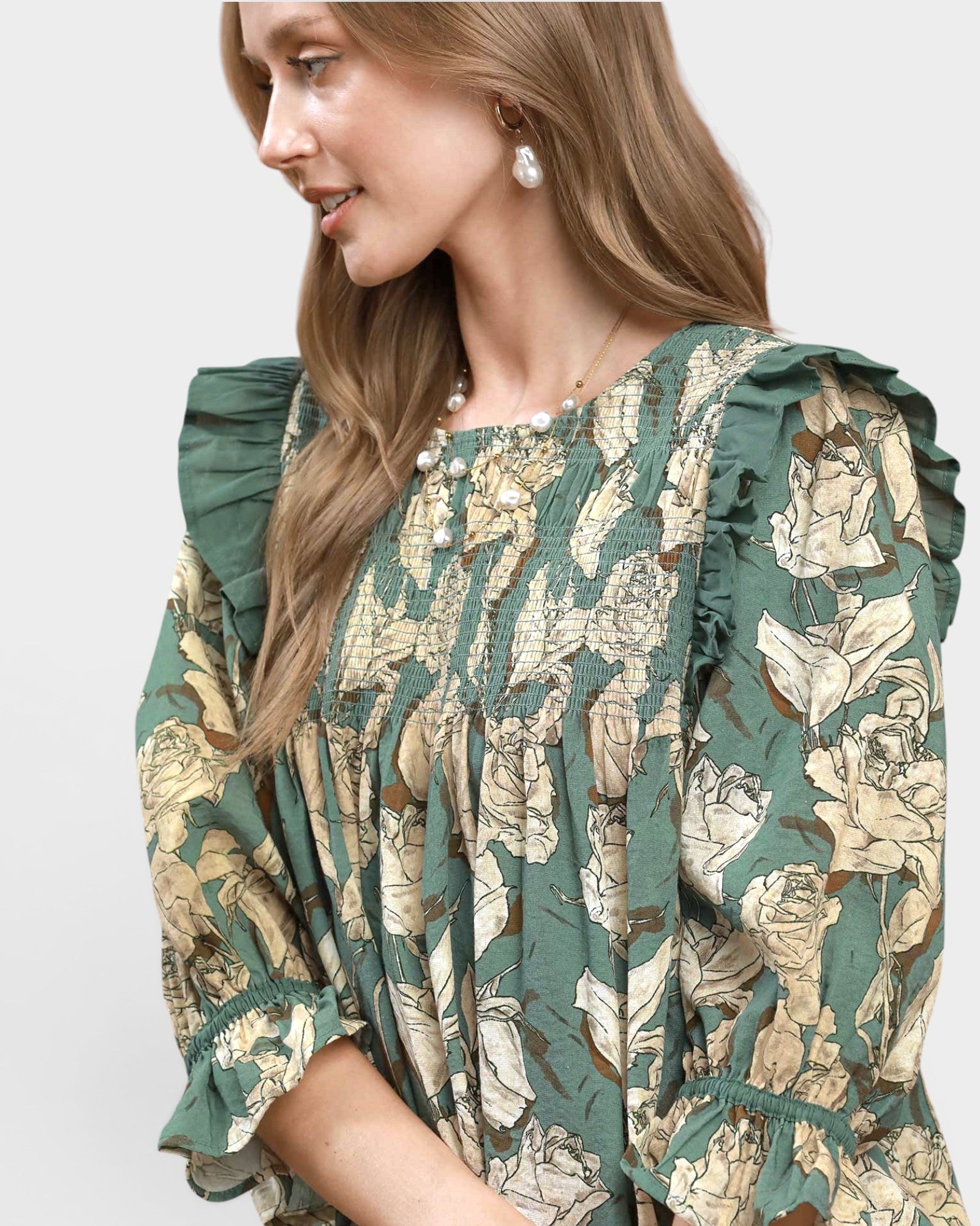 Woman wearing a floral dress with ruffled sleeves on a white background