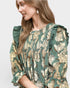Woman wearing a floral dress with ruffled sleeves on a white background