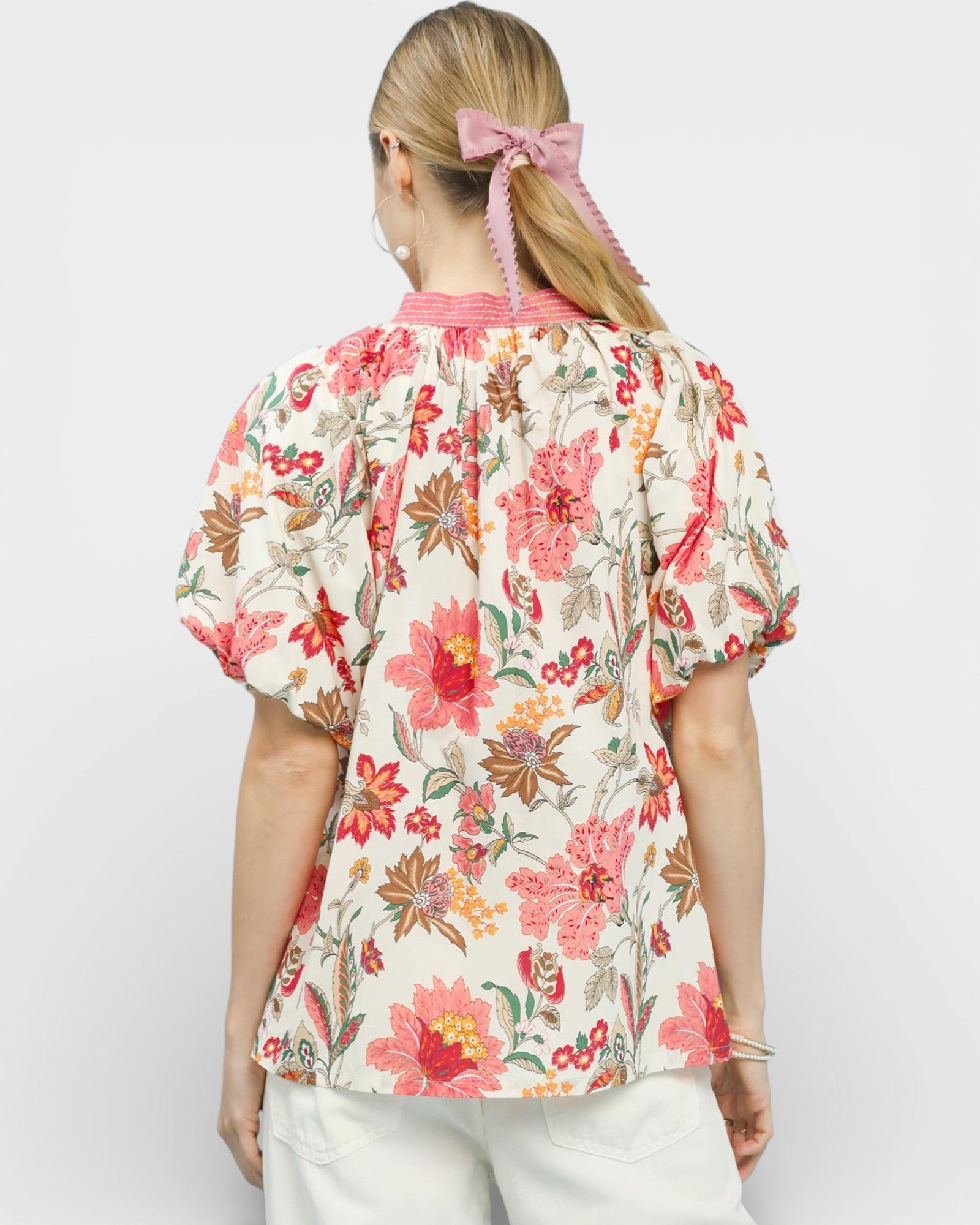 Woman wearing a floral blouse with a plain background