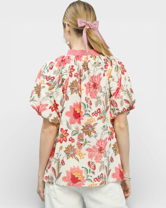 Woman wearing a floral blouse with a plain background