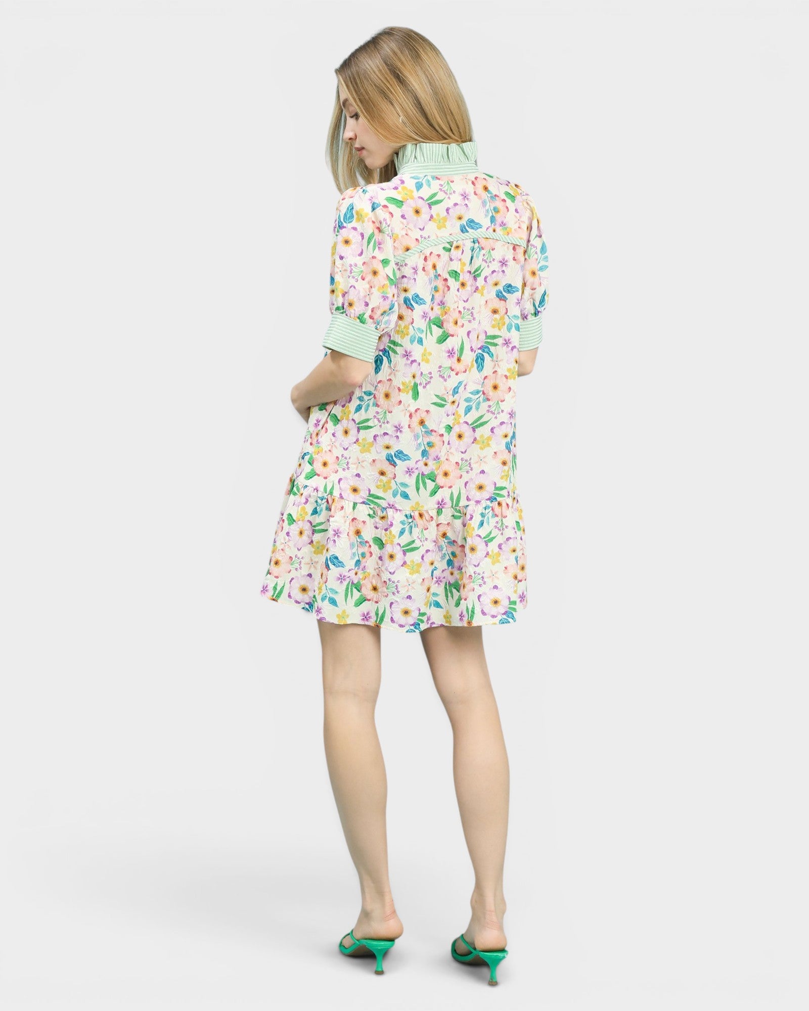 Woman wearing a colorful floral dress on a white background