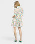 Woman wearing a colorful floral dress on a white background