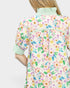 Person wearing a colorful floral dress with a white background