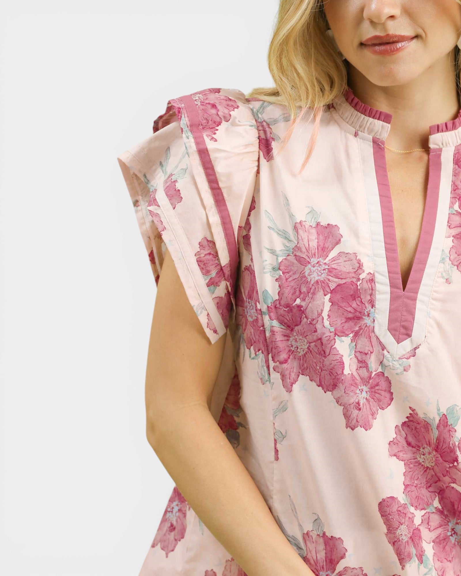 Woman wearing a floral dress with pink flowers on a white background