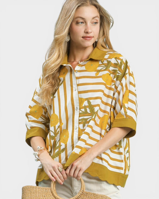 Woman wearing a yellow and white patterned shirt with a plain background