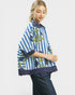 Woman wearing a blue and white striped jacket with floral patterns on a white background