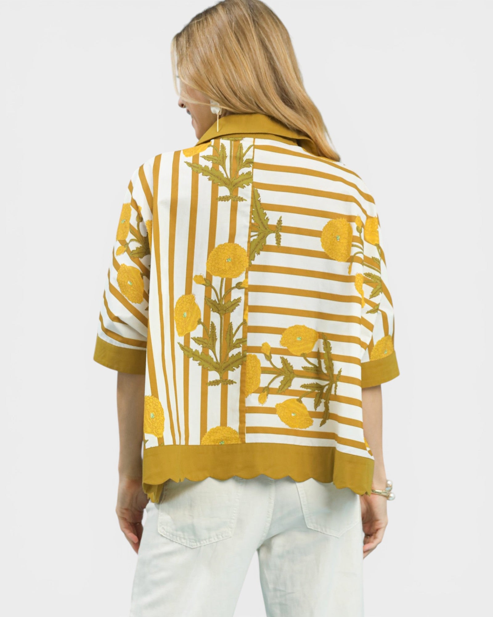 Woman wearing a yellow and white patterned shirt on a white background