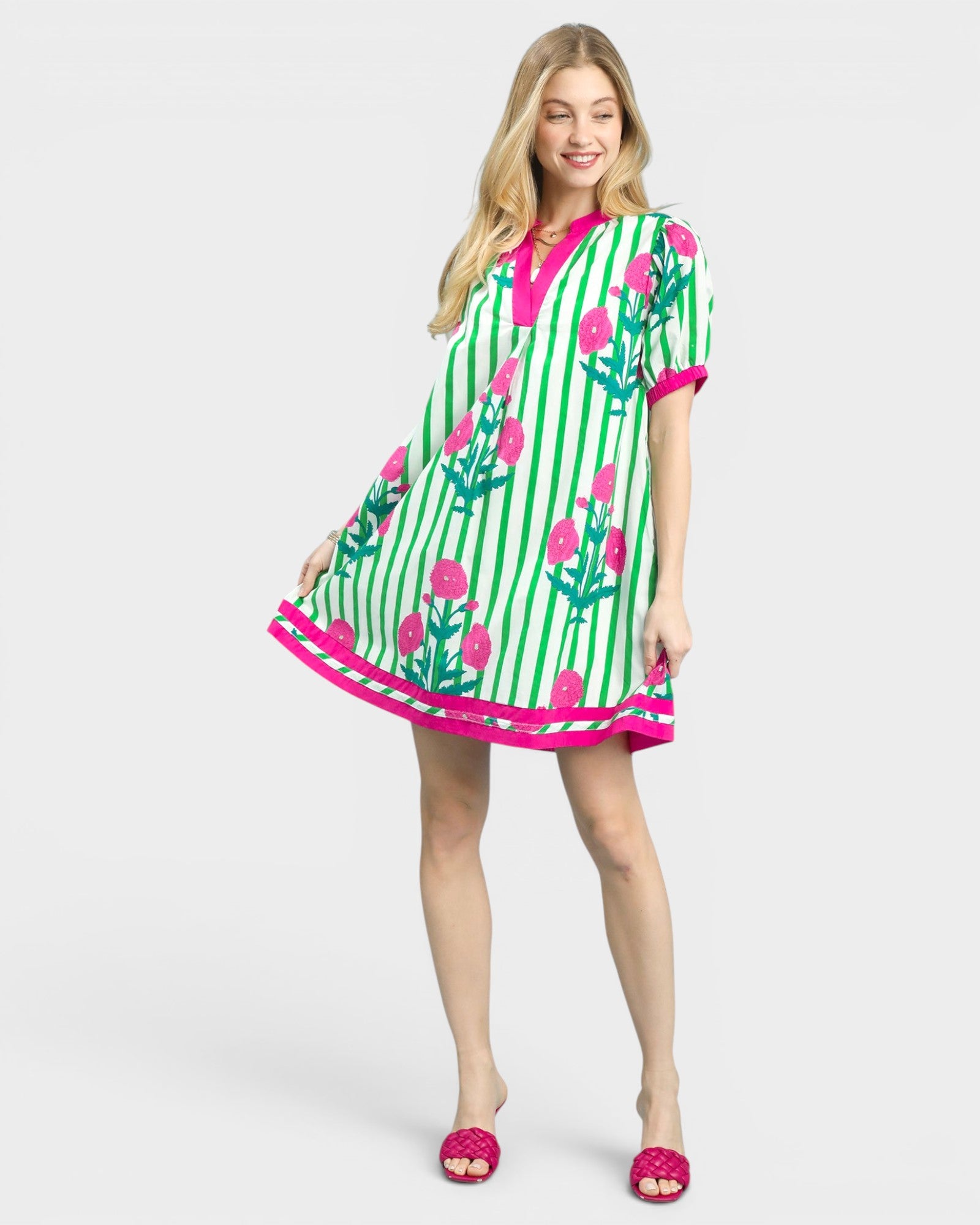 Woman wearing a green and pink patterned dress on a white background