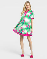 Woman wearing a green and pink patterned dress on a white background