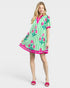 Woman wearing a green and pink patterned dress on a white background