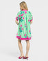 Woman wearing a green and pink dress with floral patterns on a white background