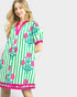 Woman wearing a green and pink floral dress with stripes on a white background