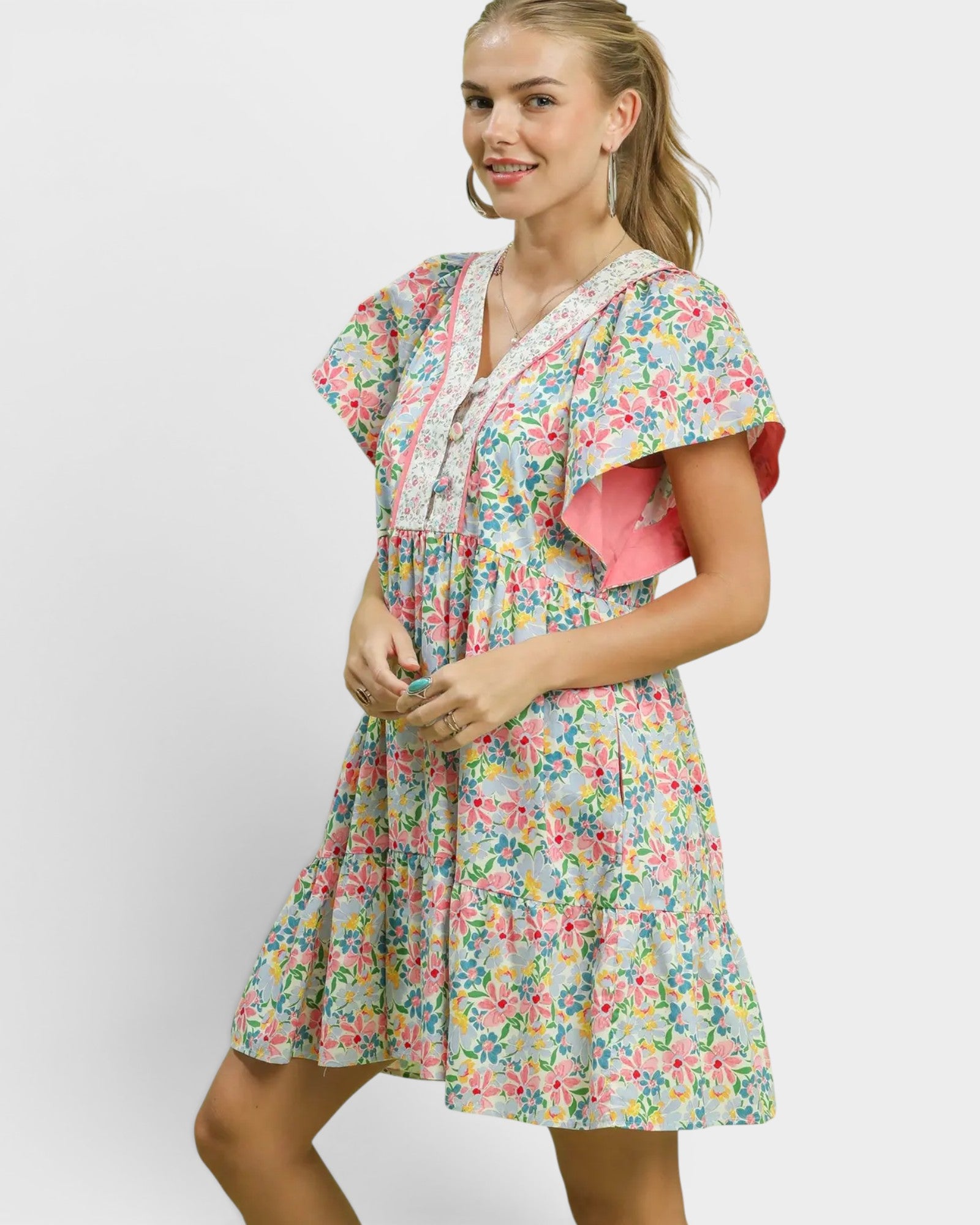 Woman wearing a floral dress with a pink top on a white background