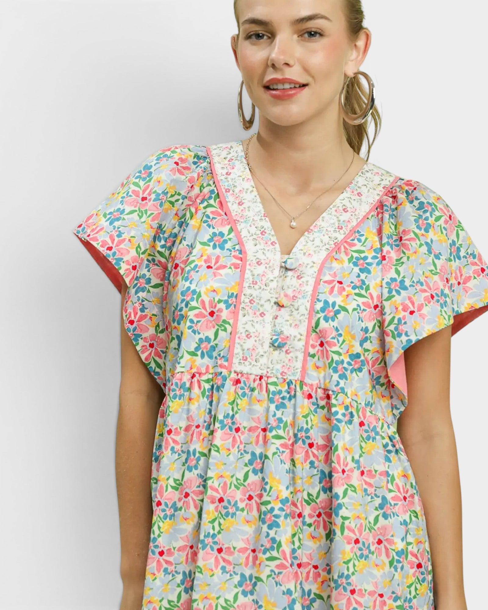 Woman wearing a colorful floral dress against a white background