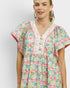 Woman wearing a colorful floral dress against a white background