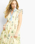 A woman wearing a light cream tiered maxi dress with a blue ruffled collar and a multicolor floral and botanical print, set against a plain white studio background.