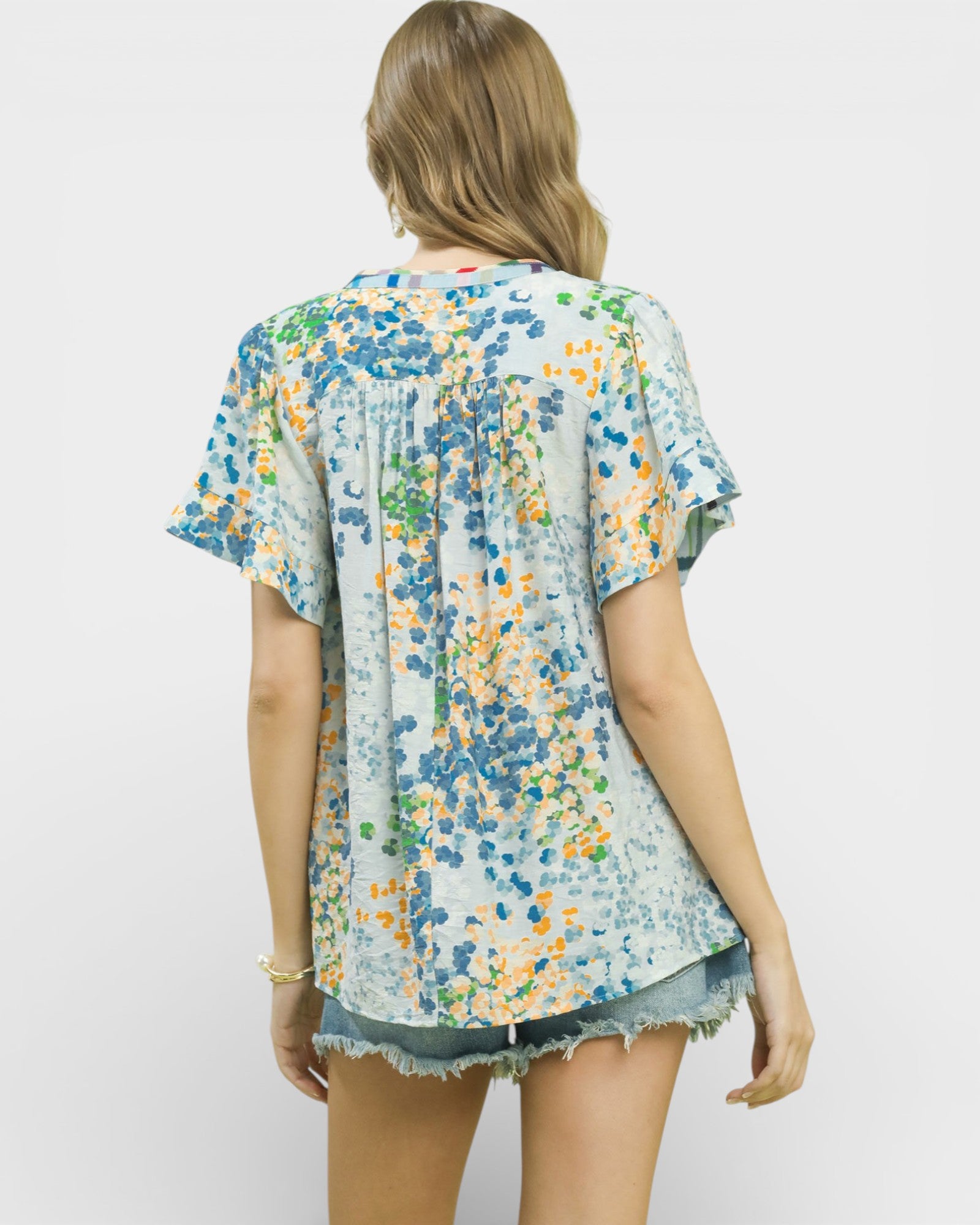 Woman wearing a floral blouse with a plain background