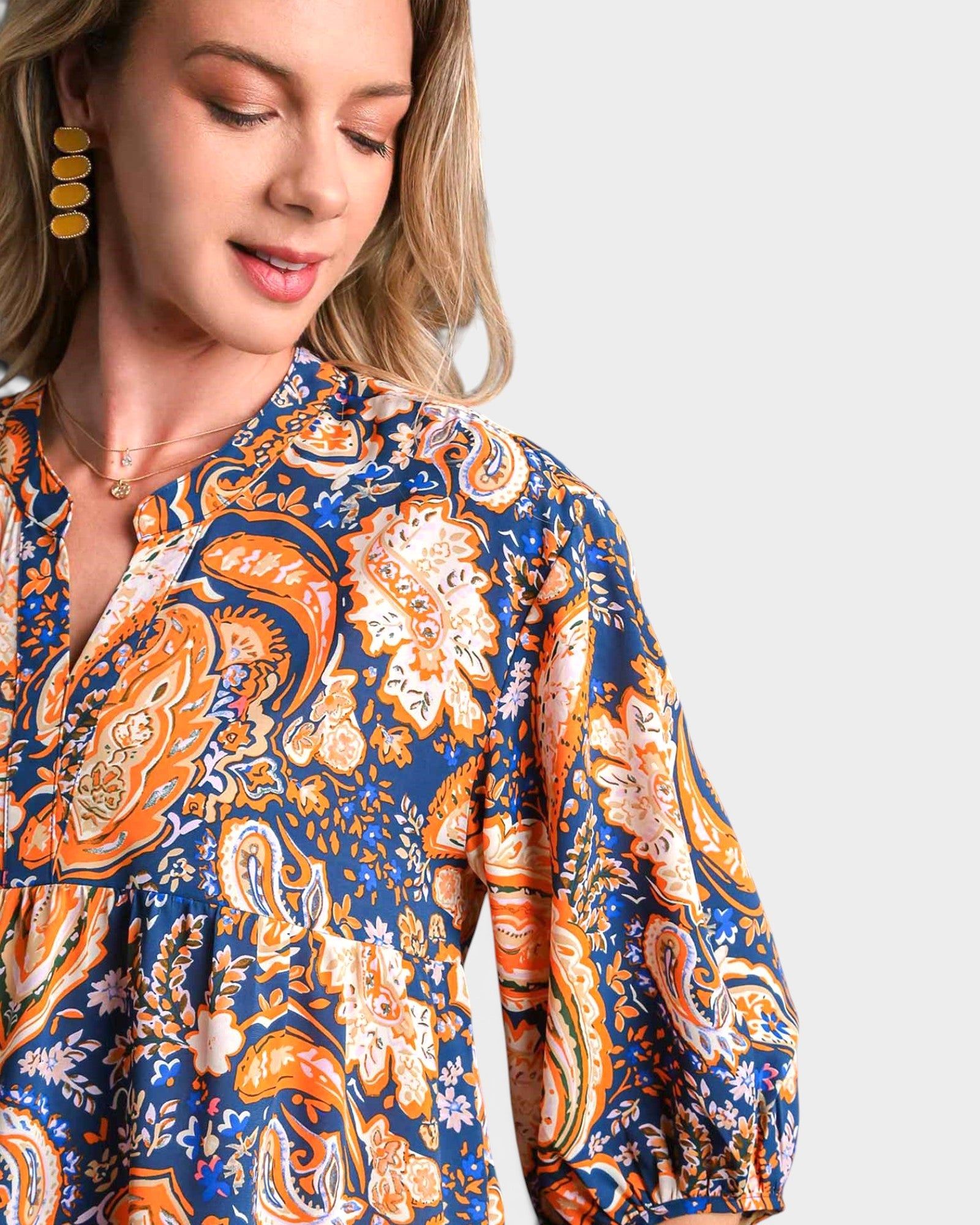 Woman wearing a patterned dress with a neutral background