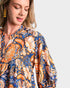 Woman wearing a patterned dress with a neutral background