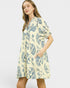 Woman wearing a yellow dress with blue floral pattern on a white background
