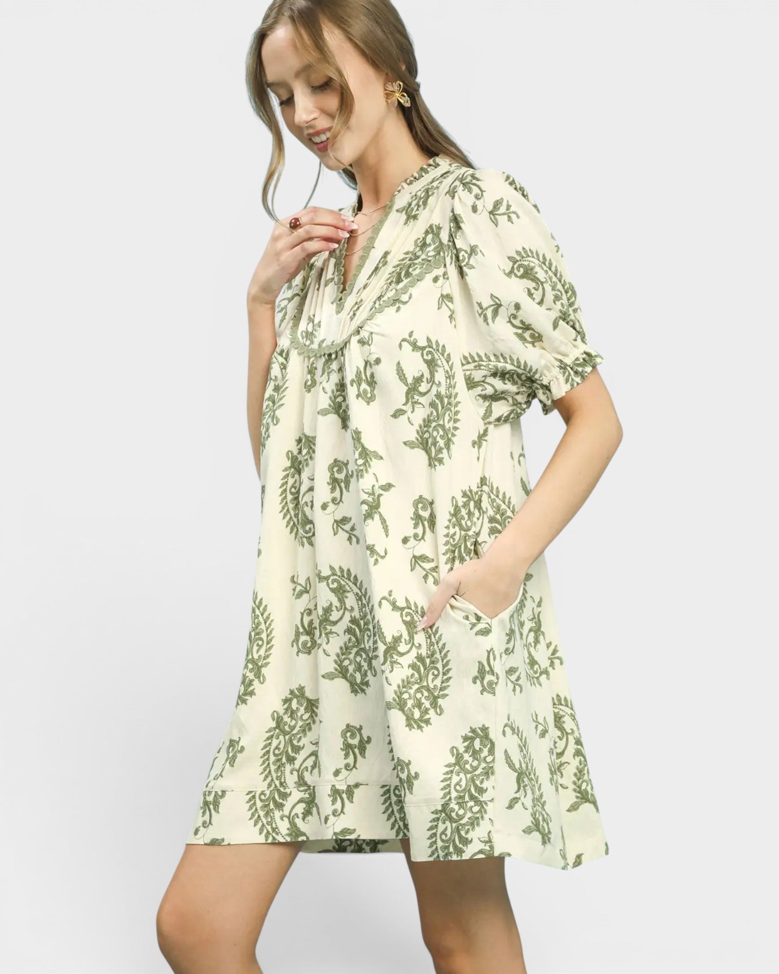 Woman wearing a green floral dress on a white background