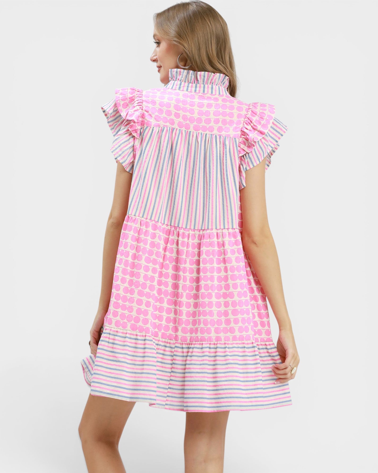 Woman wearing a dress with pink and white pattern on a white background