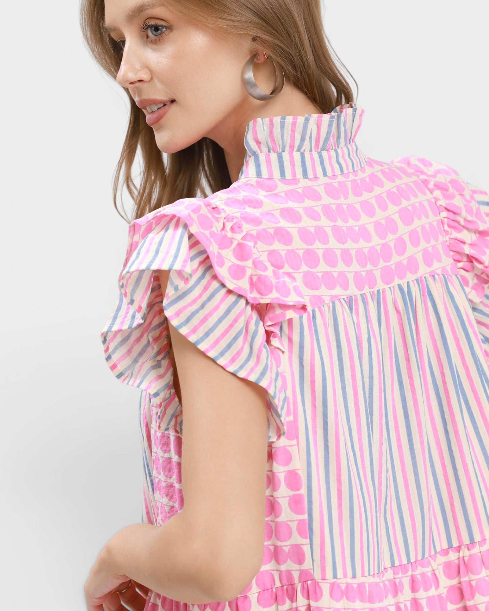 Woman wearing a colorful dress with a polka dot pattern on a white background