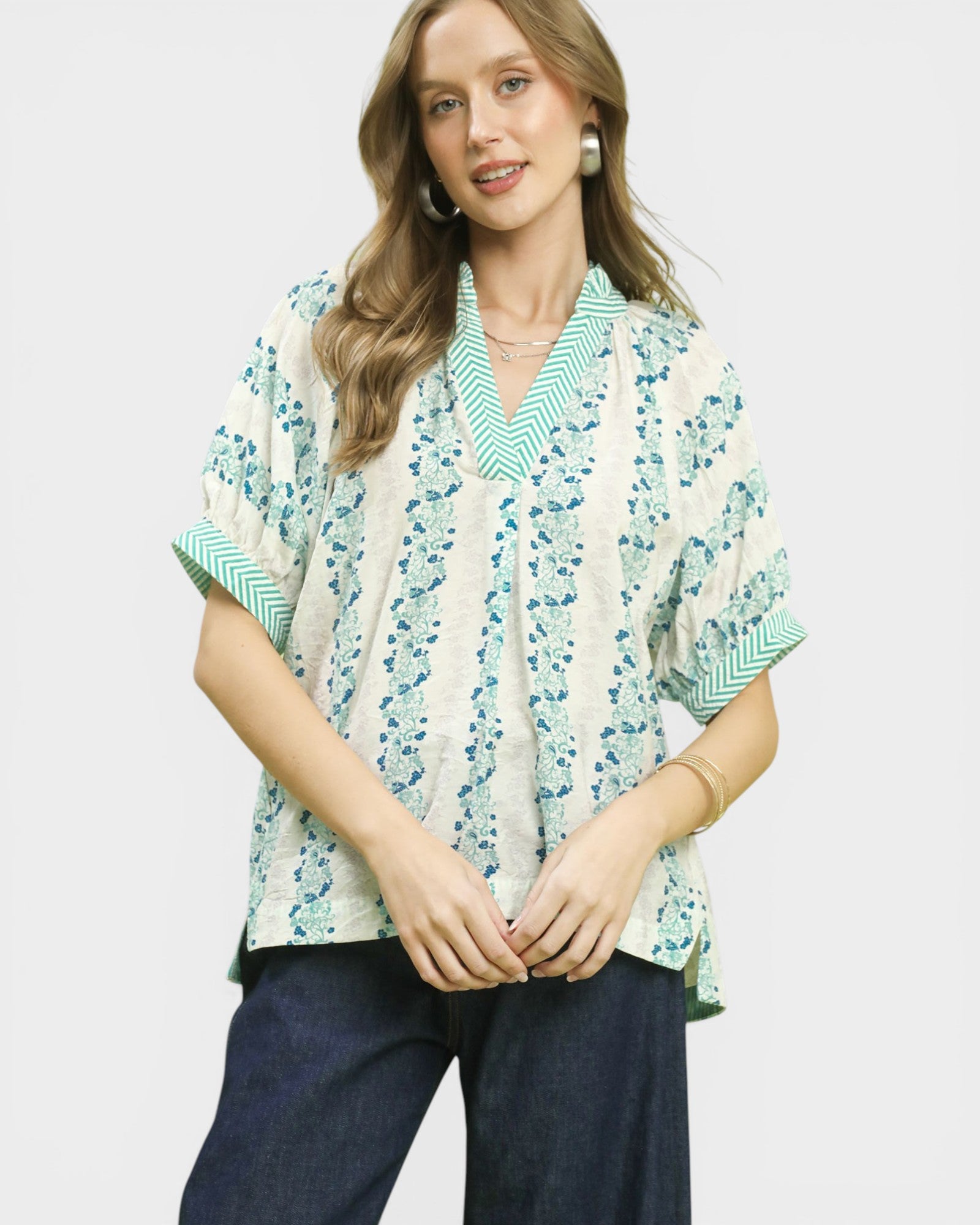 Woman wearing a patterned blouse with a plain background