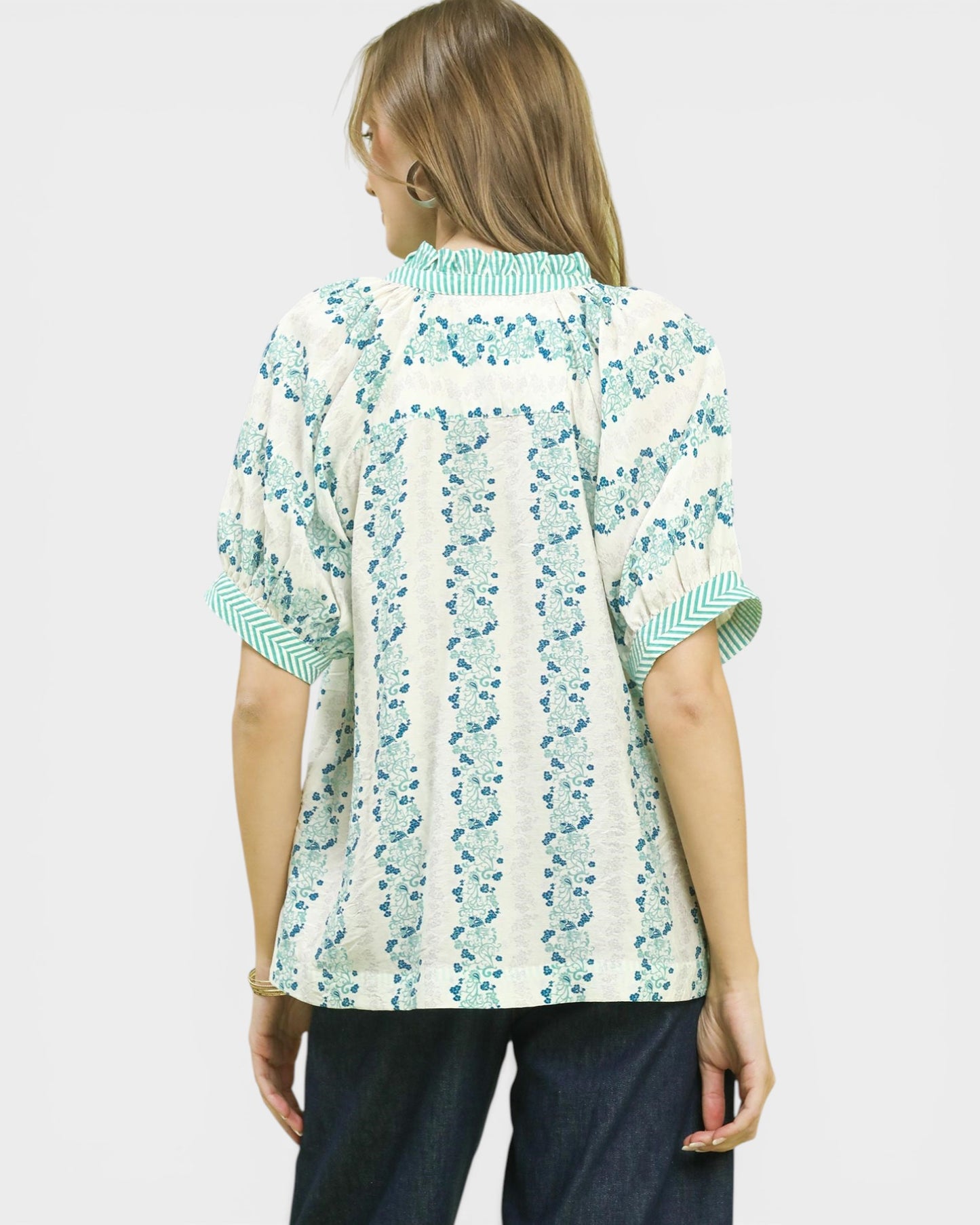 Woman wearing a patterned shirt with a white background