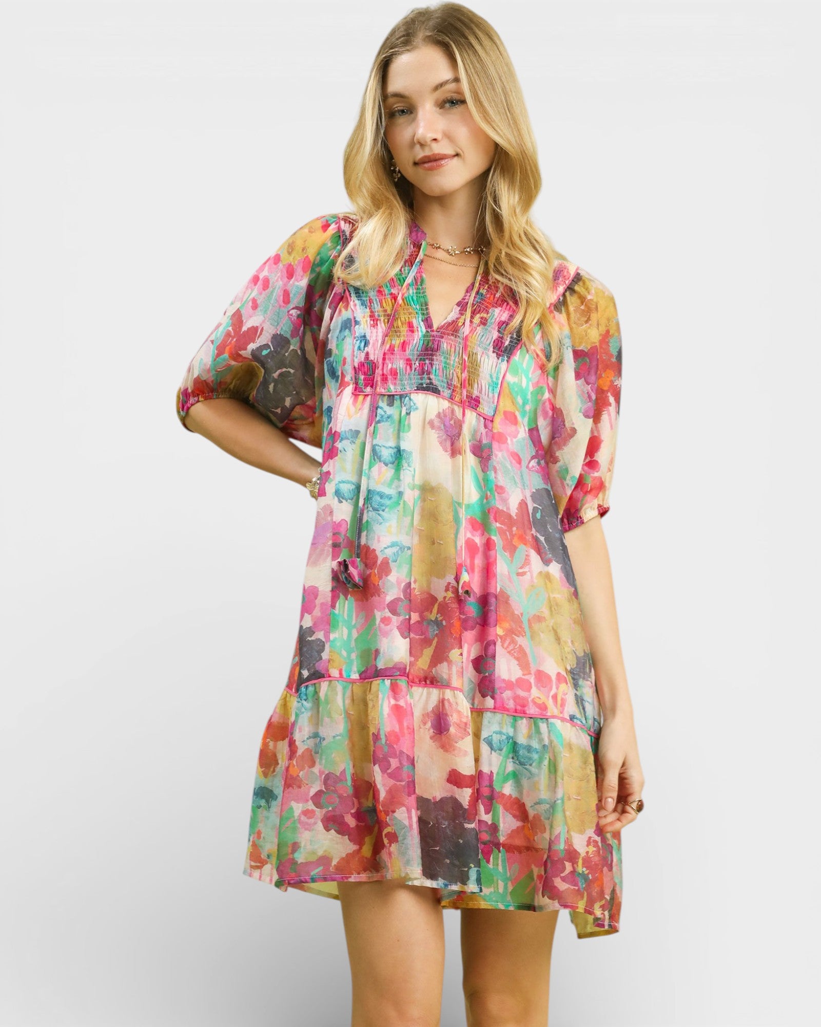 Woman wearing a colorful floral dress against a white background