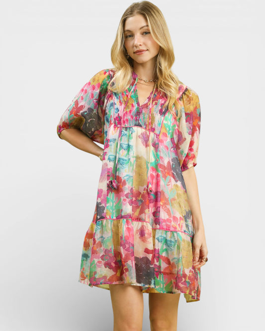 Woman wearing a colorful floral dress against a white background